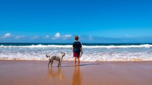 Consejos útiles para ir con perro a la playa: Niño junto a su perro en la orilla del mar